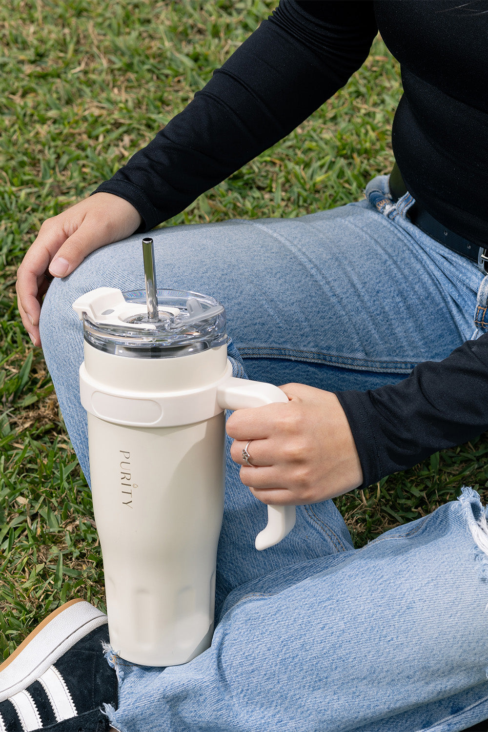 Una mano sujeta un tumbler go color blanco.